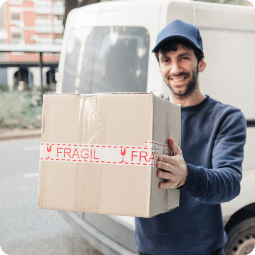 smiling-delivery-man-holding-cardboard-box 1