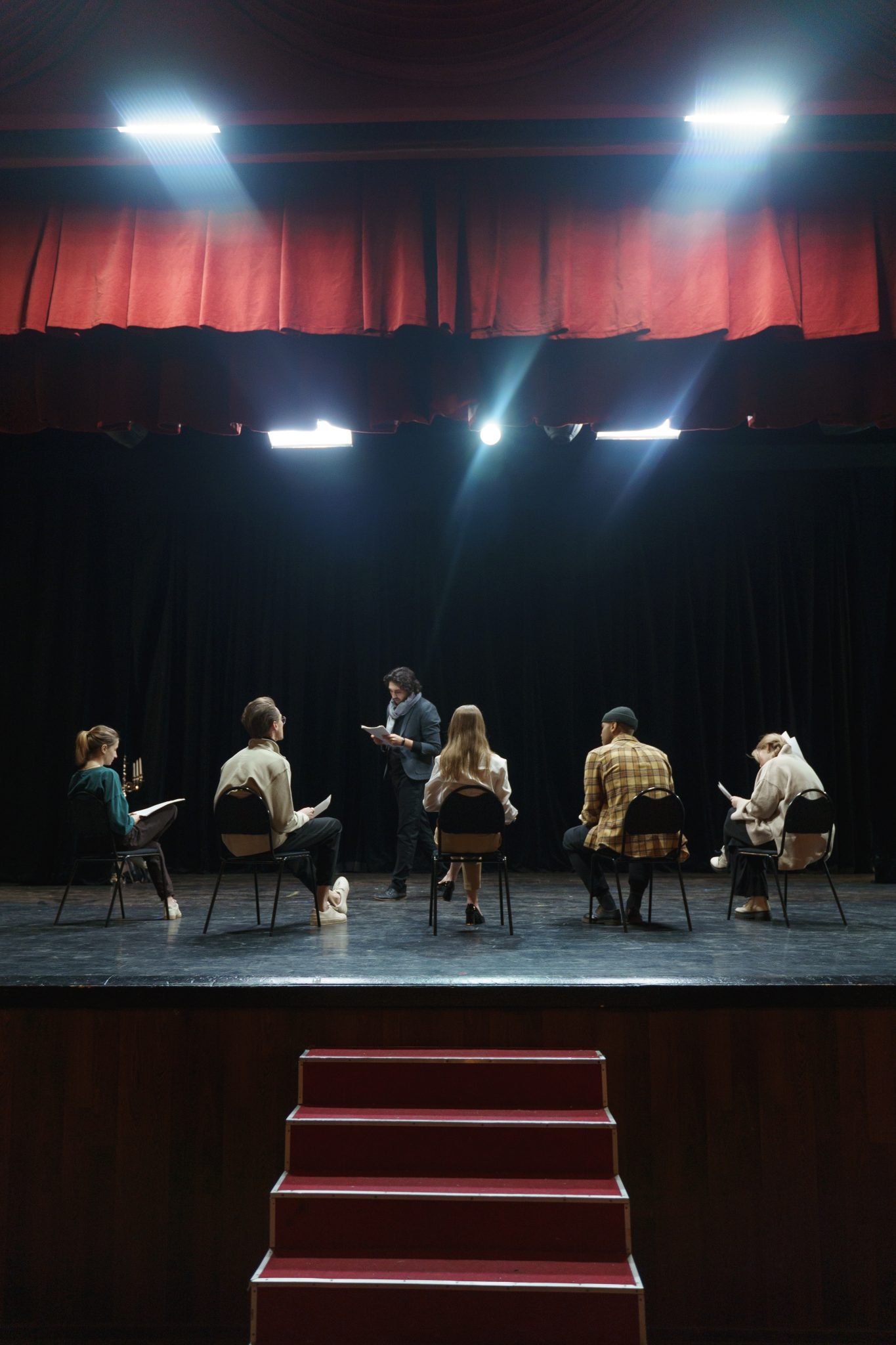 Group Of People Sitting On A Chair On Stage